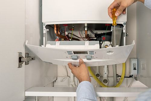 Heating technician repairing a residential boiler in Saratoga