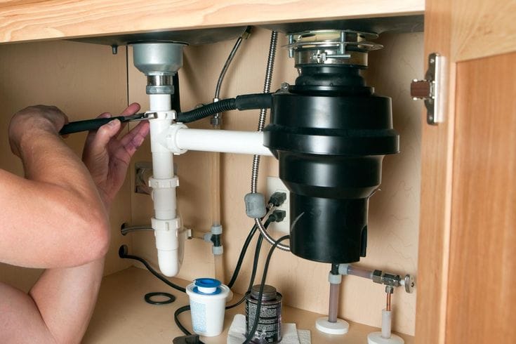 Plumber repairing a garbage disposal in Saratoga