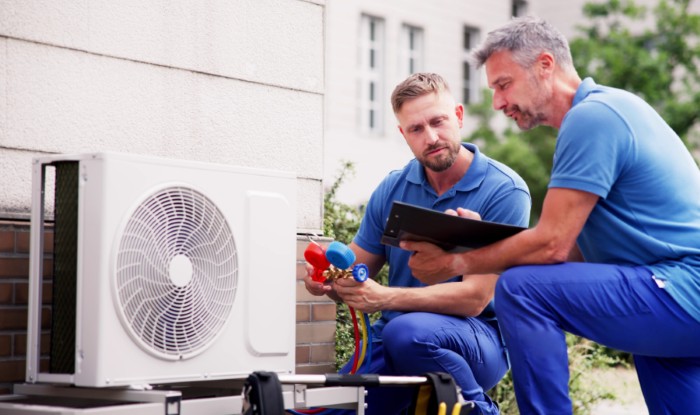 HVAC technicians installing an outdoor air conditioning unit in Saratoga