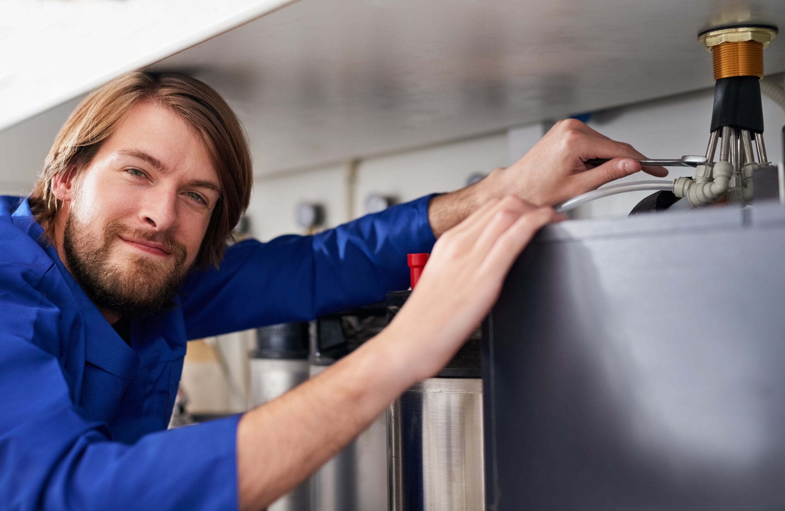 Technician servicing a residential water heater tank in Saratoga